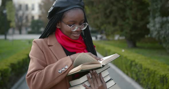 Young Black Female Student Holding Many Books in Her Hands