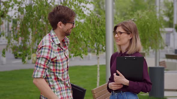 Two co-workers met during the break and talked happily.