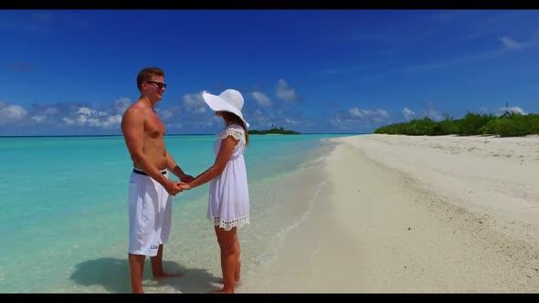 Two lovers tan on relaxing tourist beach holiday by turquoise sea and white sandy background of the 