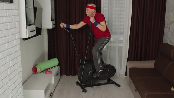 Active Healthy Senior Old Mature Man in Sportswear Using Orbitrek Training Cardio Workout at Home