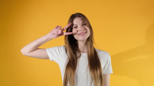 Young woman showing hand of v sign. Slow motion