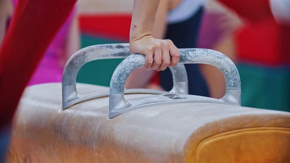 A Young Person Exercising on the Gymnastic Horse with Handles on the Tournament Swings with the Feet