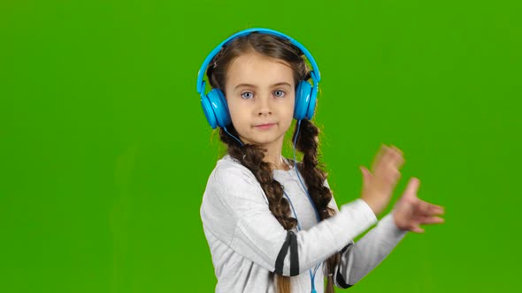 Baby in the Headphones Is Listening To Music. Green Screen