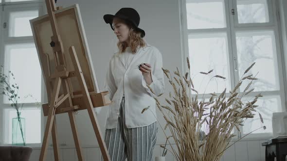 Woman Artist Paints At An Easel