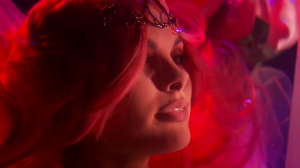 Close Up of a Woman's Face with Long Red Hair and a Tiara Under Water