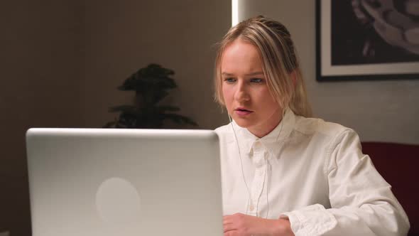 Surprised Shocked Woman in Headphones Working on Laptop Has Video Call Chatting at Home Office Woman