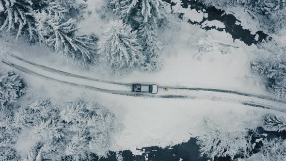 Winter Aerial Footage of a Curved Windy Road Village Cutting Through Mountains Landscape