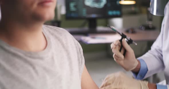 Crop Doctor Injecting Vaccine Into Shoulder of Man