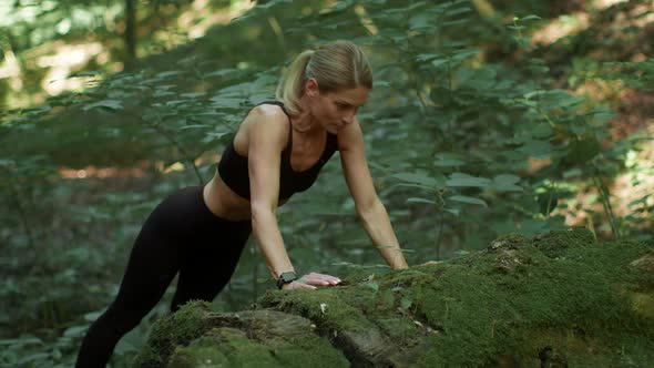 Active Middle Aged Woman Practicing Fitness at Forest Doing Pushups Leaning at Mossy Stone Tracking