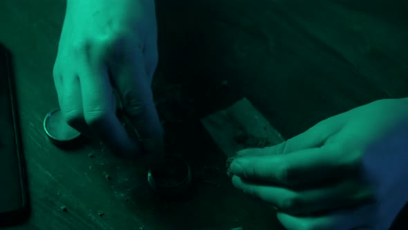 Man Rolling a Medical Marijuana Joint in Night Club