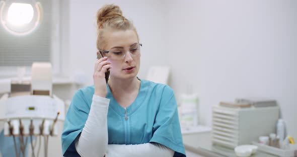 Female Doctor Talking on Mobile Phone at Healthcare Clinic