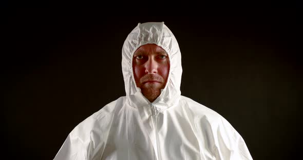 Man with a Serious and Focused Expression on Face Is Dressed in a White Protective Jumpsuit. He