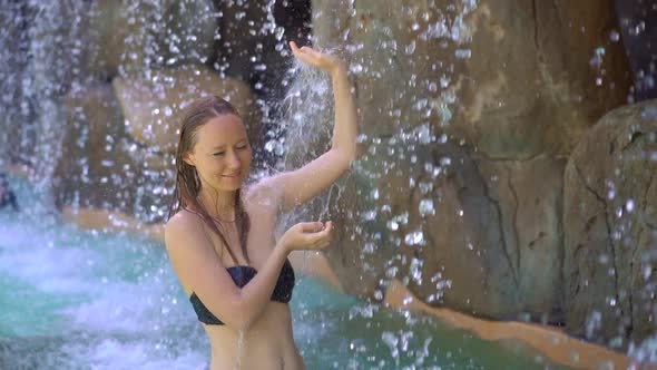 A Young Woman in a Tropical Resort with Hot Springs, Waterfalls and Swimming Pools with Hot Mineral