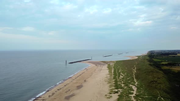 Wide landscape aerial shot flying over an empty British beach in Norfolk