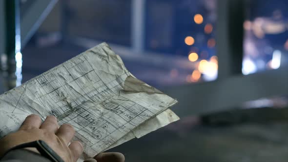 Worker Holds a Drawing in His Hands. Metal Welding. Close-up.