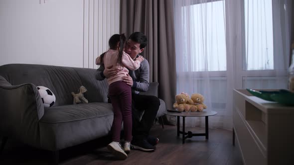 Little Girl Cuddling and Talking with Dad at Home