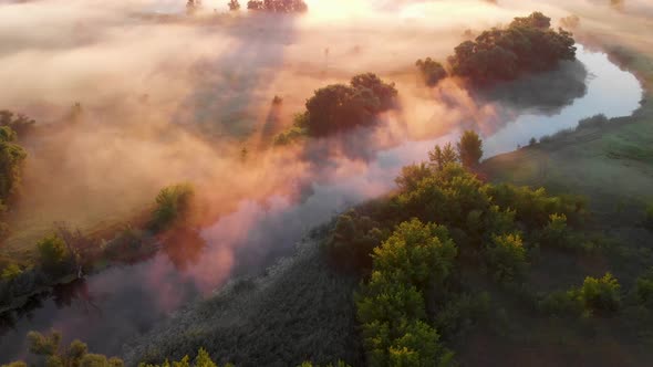 Aerial Drone View of Sunrise Over Misty River