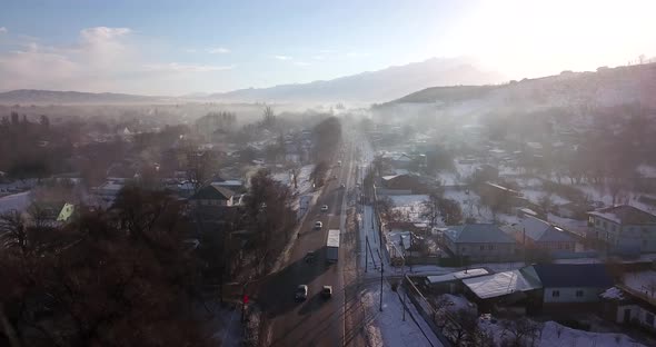 Winter Village and Highway with Cars in the Fog