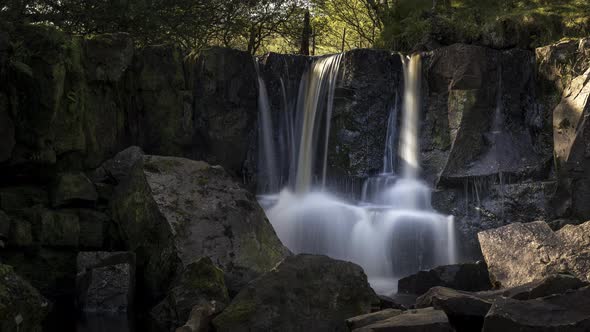 Time lapse of local waterfall in rural forest landscape of Ireland on a summer sunny day. alt