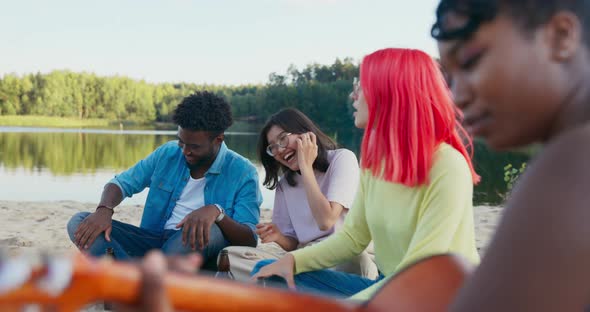 Friend's Campfire in the Open Air Outside Beautiful Girl Plays Guitar the Rest of the People Listen