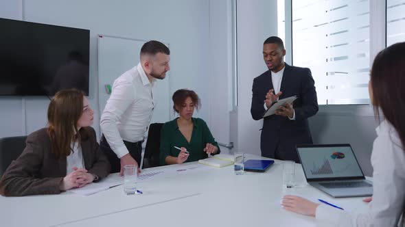 Black Manager Showing Business Analytics to Colleagues