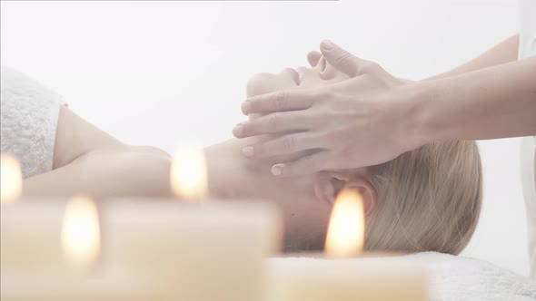 Young, healthy and beautiful woman gets massage therapy in the spa salon.