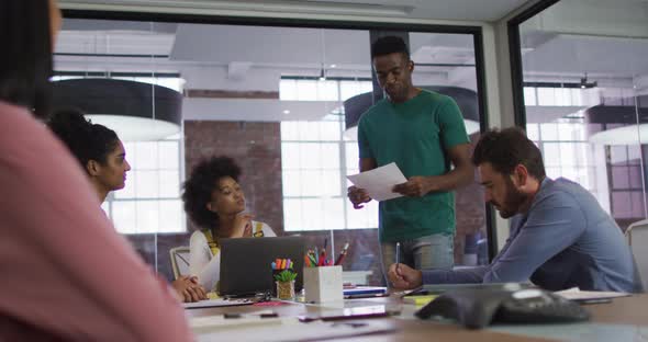 Mixed race business colleagues sitting having a discussion in meeting room