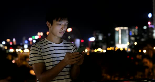 Young man using mobile phone in city