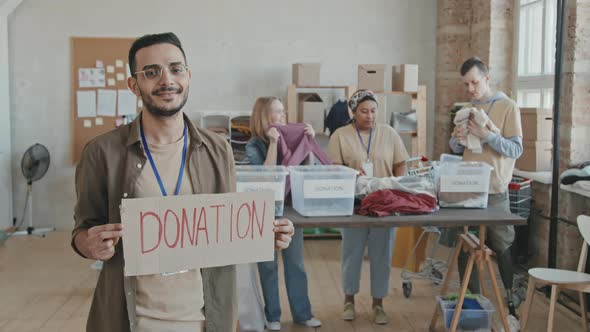 Portrait of Volunteer Holding Cardboard Donation Sign