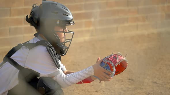 Boy plays catcher in a little league baseball game.