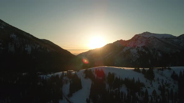 Drone Over Glowing Sunset on Snowy Mountain Tops in Brighton, Utah