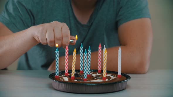 Man Is Lighting Candles on a Cake