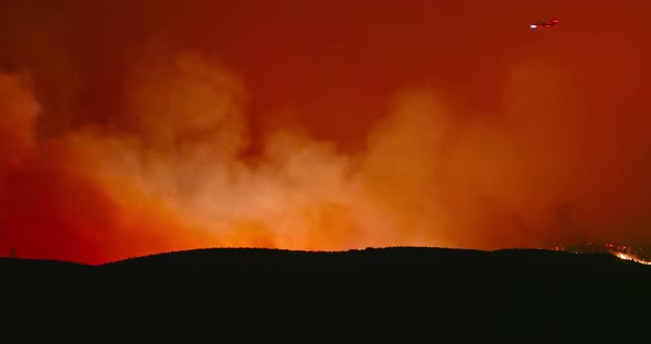 Fire Helicopter Is Flying Above Wildfire at night.California Nature Is Burning Due To Climate Change