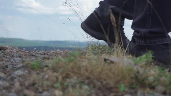 The Feet of the Tourist Step on the Rocky Ground