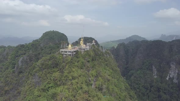 Aerial footage of Buddha on top of Tiger Cave Temple, Wat Thum Sua, stone rocks, Krabi, Thailand