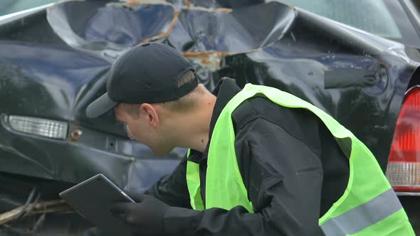 Patrol Worker Examining Car Accident Filling Online Report on Tablet, Technology