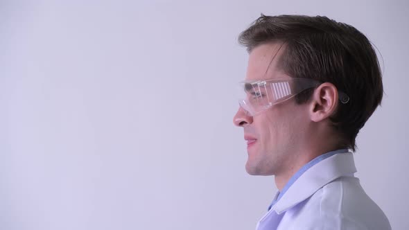 Profile View of Young Happy Handsome Man Doctor Wearing Protective Glasses