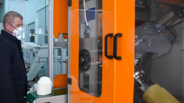 A man works at a machine for the manufacture of medical masks with nanofiber.