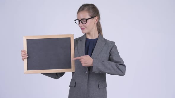 Young Happy Businesswoman Giving Thumbs Up While Holding Blackboard