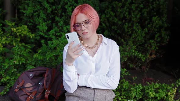 Young Woman with Pink Hair Using Smatphone