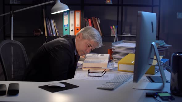Manager or employee falling asleep in office.