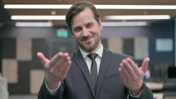 Portrait of Businessman Pointing at the Camera and Inviting