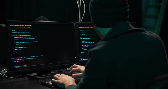 Shot From the Back to Hooded Hacker Breaking Into Corporate Data Servers From His Underground