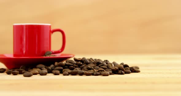 Close-up of coffee cup with saucer and coffee beans