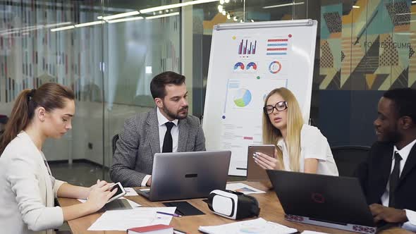 Businesswoman Get Aquainted with the Datas on Her Tablet PC and on Flip Chart Presentation