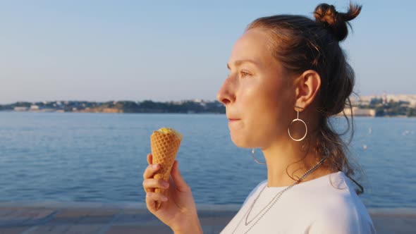 Girl Walks Along Sea Embankment Eats Ice Cream