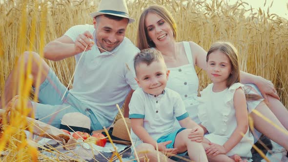 Father Tickling Son at Picnic in Field