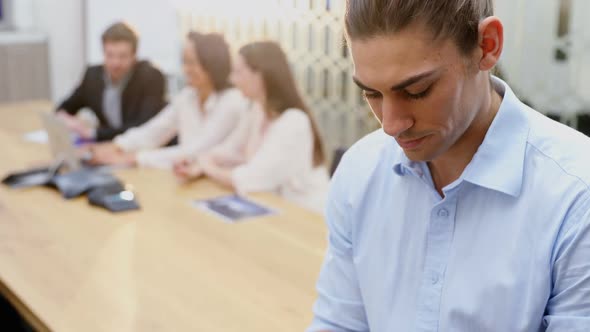 Male executive using digital tablet in conference room 4k