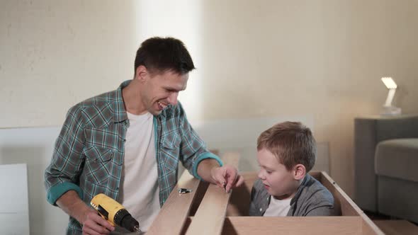 Happy Father and Son Enjoy Assembling New Closet Together