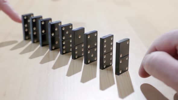 Falling dominoes. Chain reaction, built figure of dominoes falling in slow motion.